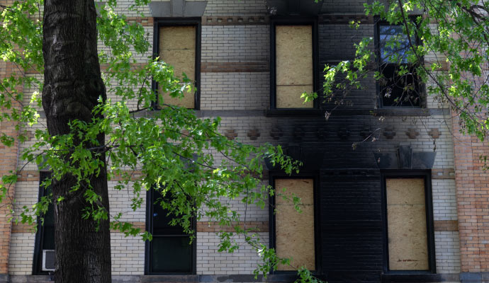 A fire damaged house with borad-up windows