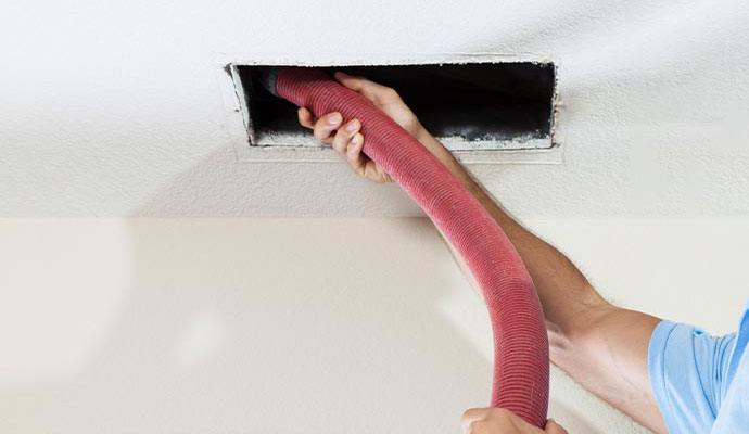 Professional worker removing smoke from duct system