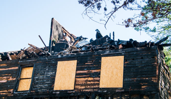 Boarded-up fire damaged house