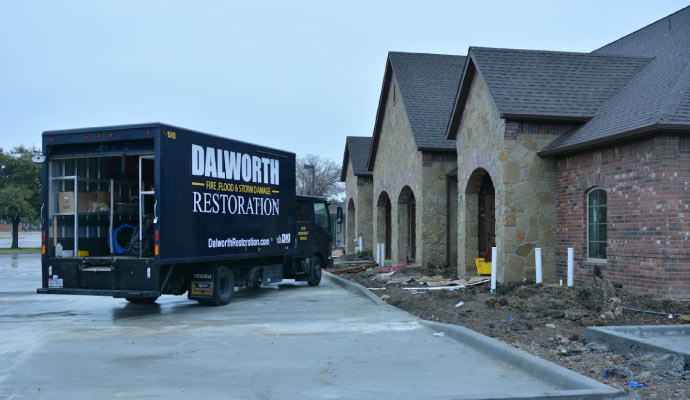 A Dalworth Restoration truck parked in front of a commercial building