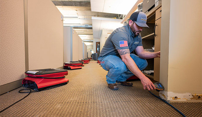 A person is assessing water damage with equipment