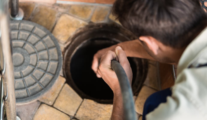 A person is inspecting sewer manhole