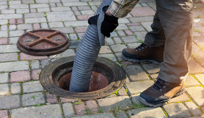 Person performing manhole maintenance service